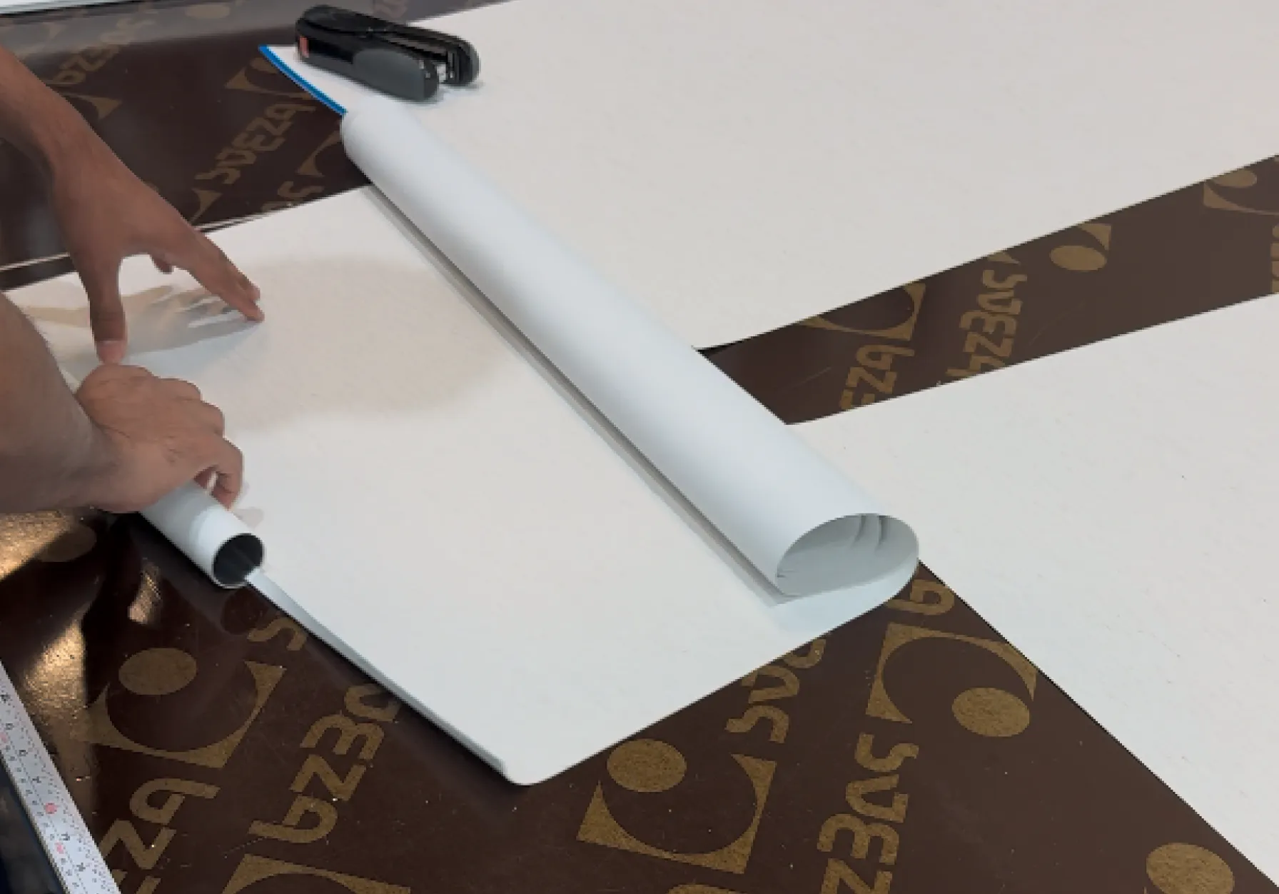 Person rolling white paper on table